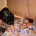 EcoFlow WAVE 3 Hot & Cool Portable AC operating inside a tent near a person resting on a sleeping mat.