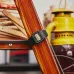 Tabletop view of Casio F-91WG-9QDF Watch resting on polished wood beside lantern and folded measuring rulers.