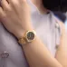 Wrist view of Casio LTP-1130N-1ARDF Watch with gold band and black dial worn with light sleeveless garment.