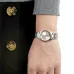 Wrist view of Casio LTP-1183G-7ADF Watch with white dial, gold markers, and date window worn under gray knitted sleeve.