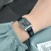 Wrist view of Casio LTP-V007L-1BUDF Ladies Watch with black dial and tag visible near green garment sleeve.