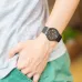 Close-up of Casio MQ-24-1B2LDF Unisex Watch with spiral gold numerals worn casually with green shorts and gray shirt.