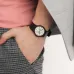 Close-up wrist view of Casio MQ-24-7B3LDF Unisex Watch with silver dial and black strap styled with gray pants.
