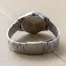 Back view of Casio MTP-V005D-7B4UDF Analog Watch showing engraved stainless steel case and clasp on wooden surface.