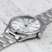 Close-up of Casio MTP-V005D-7BUDF Analog Watch with silver dial, black markers, and polished metal band on surface.