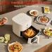 Countertop view of Xiaomi Mijia Air Fryer N1 5L open basket holding whole chicken with plates of food around.