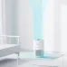 Bedroom view of Xiaomi Smart Air Purifier 4 Compact on table emitting blue airflow lines for clean air circulation.