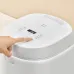 Close‑up top view of the Panasonic SR‑DL184 1.8L Rice Cooker showing a finger pressing the control panel button.