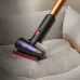 Close-up of Dyson V16 Piston Vacuum Cleaner removing pet hair from couch with illuminated brush head.