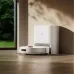 Docking view of Xiaomi H40 Robot Vacuum Cleaner beside charging station in modern home interior with sunlight.