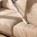 Close-up of Xiaomi Mijia Vacuum Cleaner 4 nozzle cleaning crumbs from sofa crevice with narrow brush attachment.