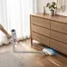 Home view of Xiaomi Mijia Vacuum Cleaner 4 used under dresser with LED light illuminating wooden floor debris.