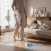Living room view of Xiaomi Mijia Vacuum Cleaner 4 cleaning wooden floor with child reading on sofa in background.