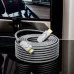 A long Dtech DT-HF8060KF 8K HDMI cable coiled on a reflective surface next to a television screen.