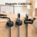 Three UGREEN magnetic cable clips attached to a wooden chest, holding cables with Lightning and USB-C connectors. One clip is open.