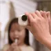 Handheld view of Insta360 GO Ultra camera with red light on, capturing indoor moment of child brushing teeth.