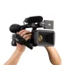 Hands hold the black Panasonic AG-CX350 professional camcorder with mic and lens hood.
