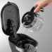 Top view of DeLonghi ICM12011 Active Line Coffee Maker with hand pouring water from carafe into reservoir.