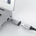 Close-up of a black Toshiba portable hard drive plugged into a MacBook laptop via a dongle.