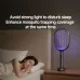 Qualitell S2 mosquito killing bat placed on bedside table emitting soft purple light while woman sleeps peacefully