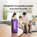 Qualitell V3 mosquito bat on wooden table emitting purple light with family relaxing in background