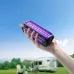 Hand holding Qualitell V3 mosquito swatter bat glowing with purple grid in outdoor camping setting