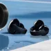 Close-up of Anker Soundcore C50i earbuds on blue surface with water droplets highlighting sleek design and durability.