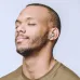 Close-up of a smiling man with his eyes closed wearing a silver BWOO BW95 earbud.