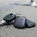 UGREEN Bluetooth tracker attached to keys on pavement, compact square design for locating lost items outdoors