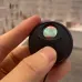 Close-up view of XO CRP02 Hidden Camera Detector showing lens area and control button held between fingers