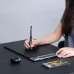 Huion Inspiroy Dial 2 Graphics Tablet shown in use on a desk with stylus, tablet, and accessories.