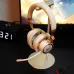 Lifestyle desk view of Havit FUXI-H8 Open-Ear Headphone placed on stand with RGB lighting visible beside gaming setup