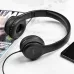 Angled view of the black Hoco W21 Graceful Charm Wired Headphone placed beside a magazine and smartphone