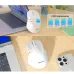 Desk lifestyle view of the Meetion BTM032R Tri Mode Wireless Mouse in white showing compact design beside laptop and accessories.