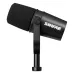 Angled view of the black Shure MV7X broadcast dynamic microphone with a foam windscreen and yoke.