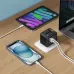 The black BWOO BO-UC06 adapter is charging a phone and tablet on a wooden desk.