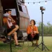 Portable tripod setup beside van with smartphone mounted, ideal for outdoor video, music, and content creation.