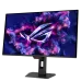 A straight-on view of the black ASUS ROG Strix OLED XG27ACDMS monitor on its stand, displaying a yellow TUF Gaming logo and graphics.