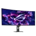 A head-on view of the curved black ASUS ROG Strix OLED XG34WCDG ultrawide gaming monitor displaying a purple and magenta ROG logo on the screen.