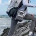 Outdoor hiking view of Anker SOLIX C300 Portable Power Station attached to backpack near rocky ocean terrain.