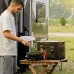 Outdoor lifestyle view of a man cooking near a camper van with the Jackery Explorer 3000 v2 3600W Portable Power Station.