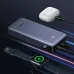 Dark blue UGREEN PB532 power bank with a digital screen, charging a smartwatch and wireless earbuds simultaneously.
