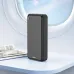Black BWOO BO-P71 power bank on a table next to a magazine, set against an airplane window view of the sky.