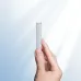 A hand holds the silver BWOO BO-P76 magnetic power bank by its side, highlighting its slim profile against a bright, airy background.
