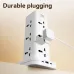 A white Deli power tower with a plug inserted into one of the multi-standard sockets, illustrating its durability.