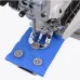 Close-up of the Jack T1377E button sewing machine needle stitching a brown button onto a piece of blue fabric.