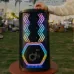 Close-up of Anker Soundcore Rave 3S Speaker on wooden table with chevron LED lights in festive outdoor party setting.