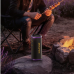 Awei KA86 Portable Bluetooth Speaker placed outdoors by a campfire highlighting portable entertainment use outdoors