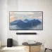 Lifestyle view of The Samsung HW‑B650F B‑Series 3.1ch Dolby Soundbar mounted under a TV with the subwoofer beside it.