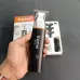 Handheld view of Kemei KM-779 Hair Trimmer with packaging box and accessories including attachments and cable.